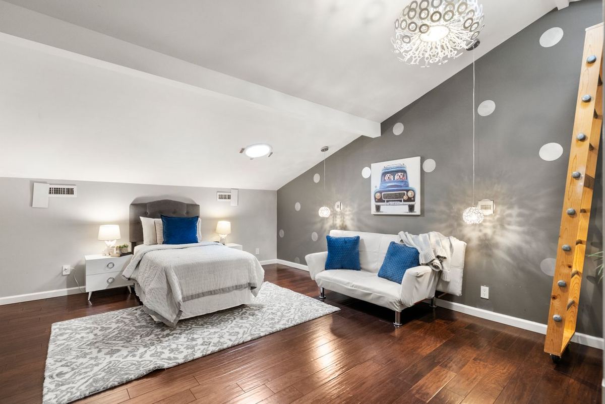 Loft bedroom with sloped ceiling and pendant lights