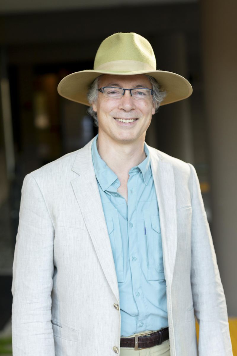 Portrait of Tomas Kandl in a linen jacket and hat